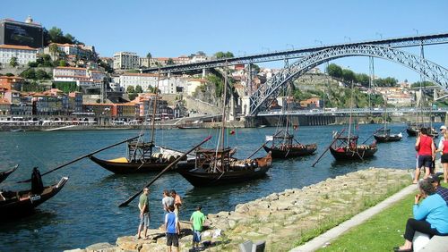 People by rabelo boats moored on douro river