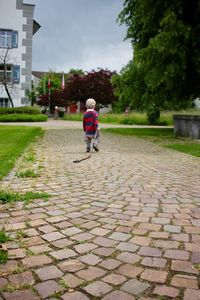 Rear view of woman walking on footpath