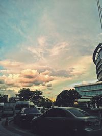 Cars on road against sky in city