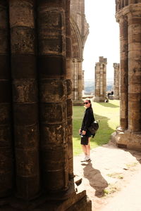 Low angle view of man standing against wall