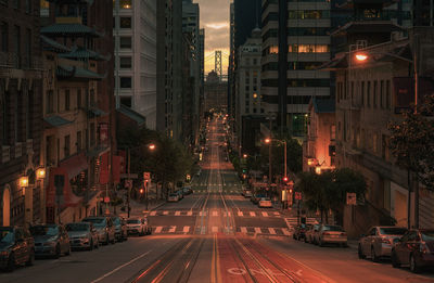City street amidst buildings during sunset