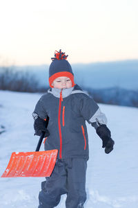 Boy standing on field during winter