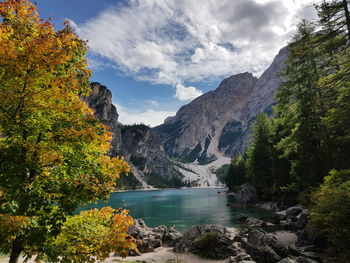 Scenic view of lake by trees and mountains against sky