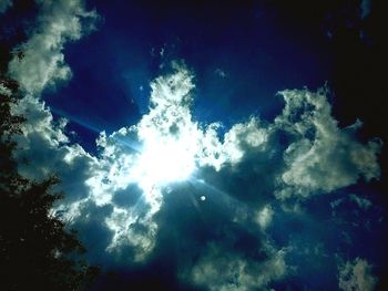 Low angle view of sun in blue sky