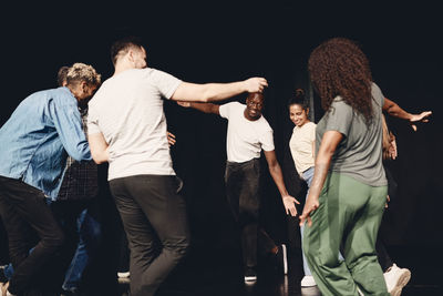 Multiracial male and female stage performers dancing during rehearsal in class