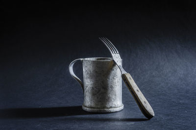 Antique metal mug with a fork