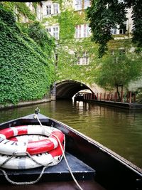 Boat moored on river by trees