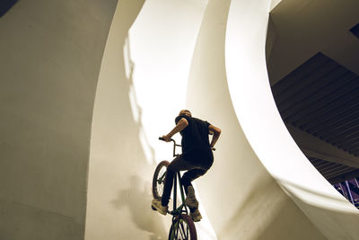 Man riding bicycle on staircase of building