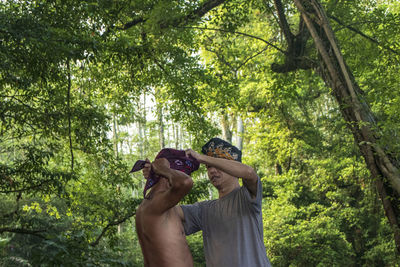 Man photographing through smart phone in forest