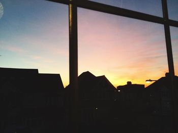 Silhouette buildings against sky at sunset