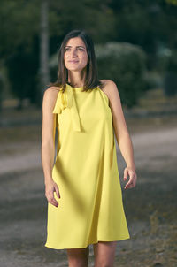 Woman standing against trees on road