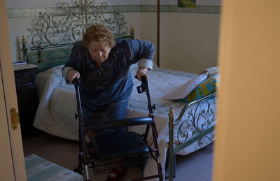 Woman sitting on bed at home