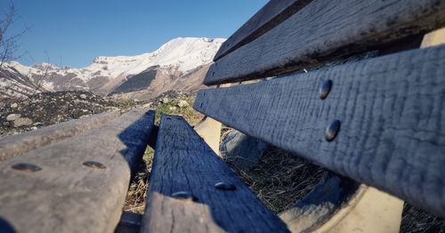 Close-up of snow on wood against sky