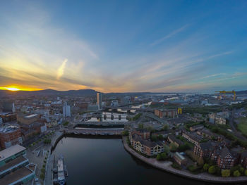 High angle view of river and buildings against sky during sunset