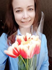 Portrait of smiling woman holding flower bouquet