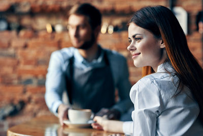 Close-up of young woman with coffee cup