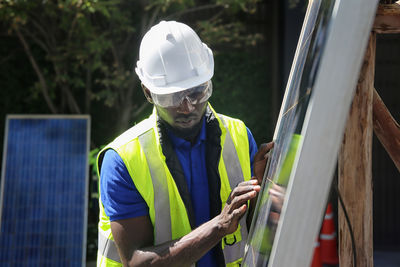 Engineer inspecting solar panel outdoors