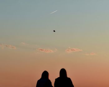 Low angle view of silhouette birds flying against sky during sunset