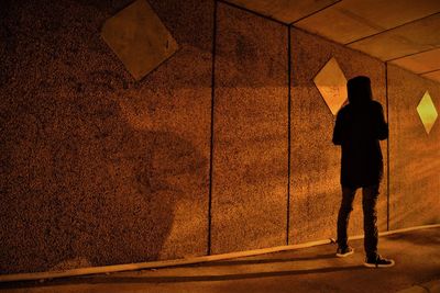Rear view of silhouette man standing on road