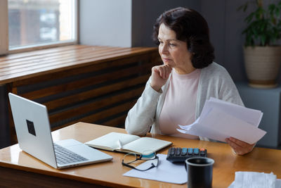 Young man using laptop at desk in office