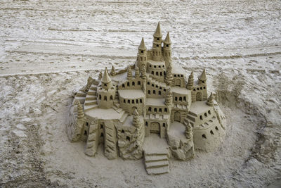 Sand castle with towers on the beach in summertime