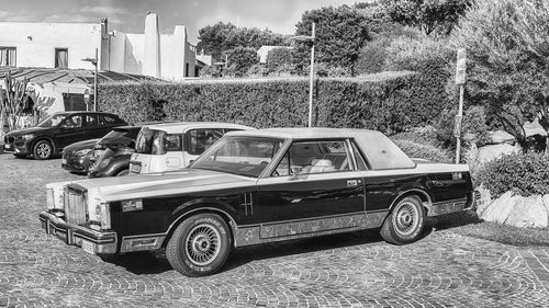 Vintage car on road by buildings in city