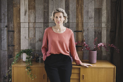 Portrait of a smiling young woman standing on table