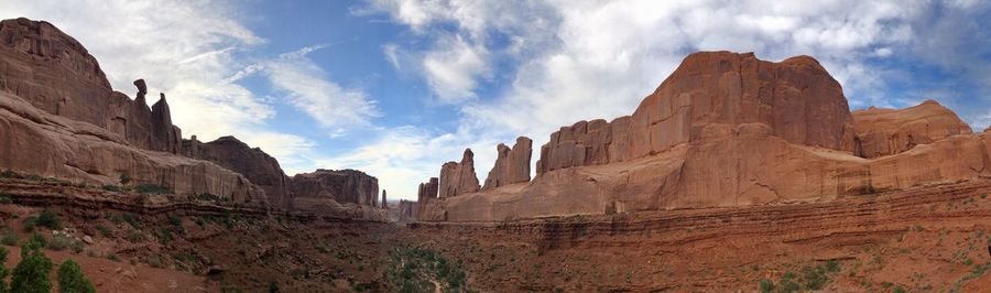 Low angle view of rock formations against cloudy sky