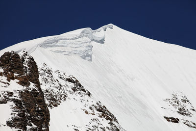 Low angle view of snowcapped mountain against sky