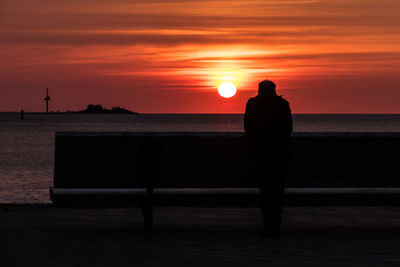 Silhouette man against sea during sunset