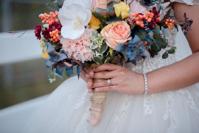 Midsection of woman holding flower bouquet