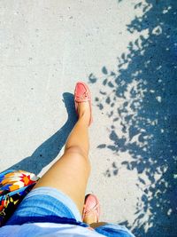 Low section of woman walking on road