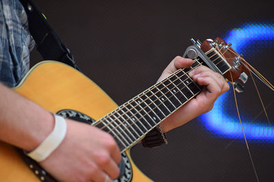 Cropped image of musician playing guitar at concert