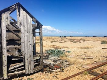 Abandoned railroad tracks and hut on shingle beach
