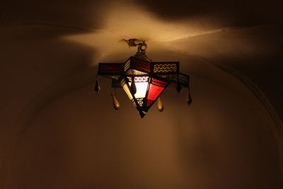 Low angle view of illuminated chandelier hanging on wall