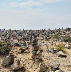 Stack of rocks on land against sky