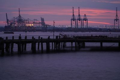 Pier over sea against sky during sunset