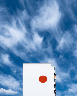 Low angle view of telephone booth against blue sky