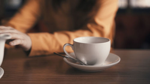 Midsection of woman using mobile phone on table