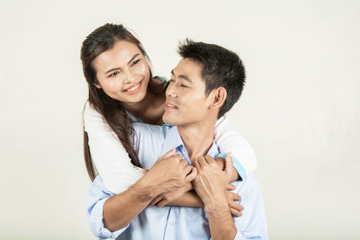Young couple kissing against white background