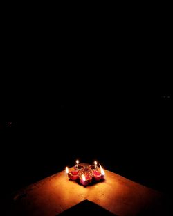 Illuminated christmas lights on table in darkroom