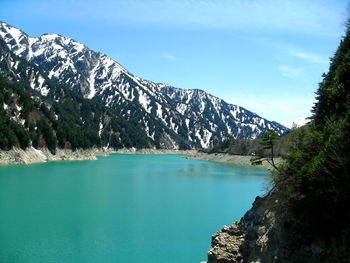 Scenic view of lake and mountains against blue sky