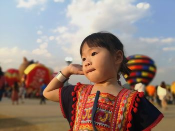 Cute girl looking away against sky