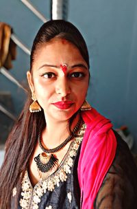 Portrait of young woman wearing traditional clothing and jewelries at home