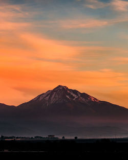 Scenic view of silhouette mountains against romantic sky at sunset