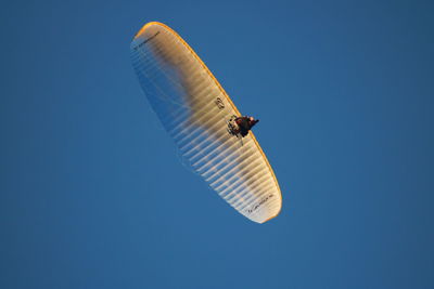 Low angle view of kite flying against clear blue sky