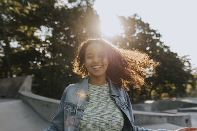 Smiling teenage girl looking at skate park looking away