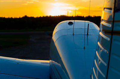 Close-up of airplane against sky during sunset