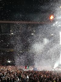 Crowd at music concert against sky at night