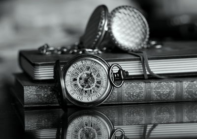 Close-up of pocket watches and books on table